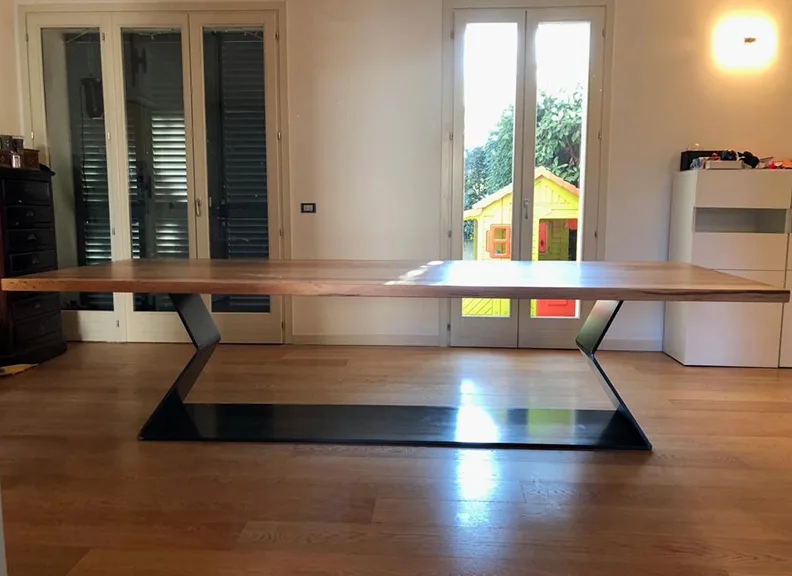 Tavolo con piano in legno e struttura geometrica portante in metallo verniciato