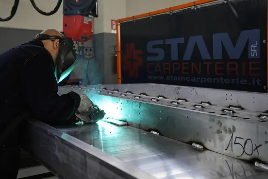 Operatore STAM durante la saldatura di una struttura metallica di grandi dimensioni