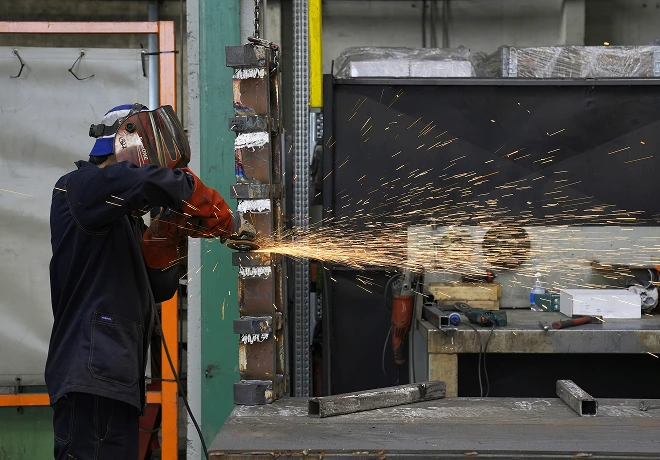 Operatore STAM durante la lavorazione di una struttura metallica in officina
