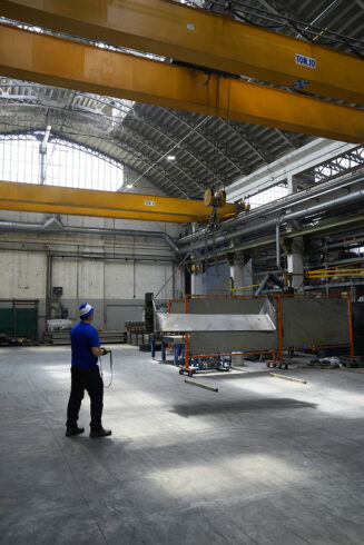 Operatore STAM movimenta un manufatto metallico con gru a ponte radiocomandata
