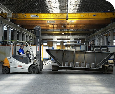 Movimentazione di una struttura metallica nello stabilimento STAM con carrello elevatore e gru a ponte